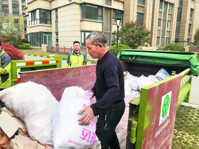 裝修工人將建筑垃圾裝袋后放入小區(qū)集中分類處置箱內(nèi)
