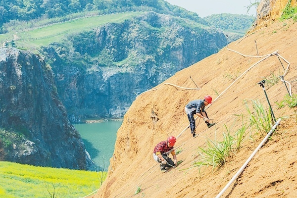 3月28日,武漢市江夏區(qū)靈山生態(tài)文化旅游區(qū)“礦花苑”景區(qū)一期,施工人員在覆土的山體上種植樹種。